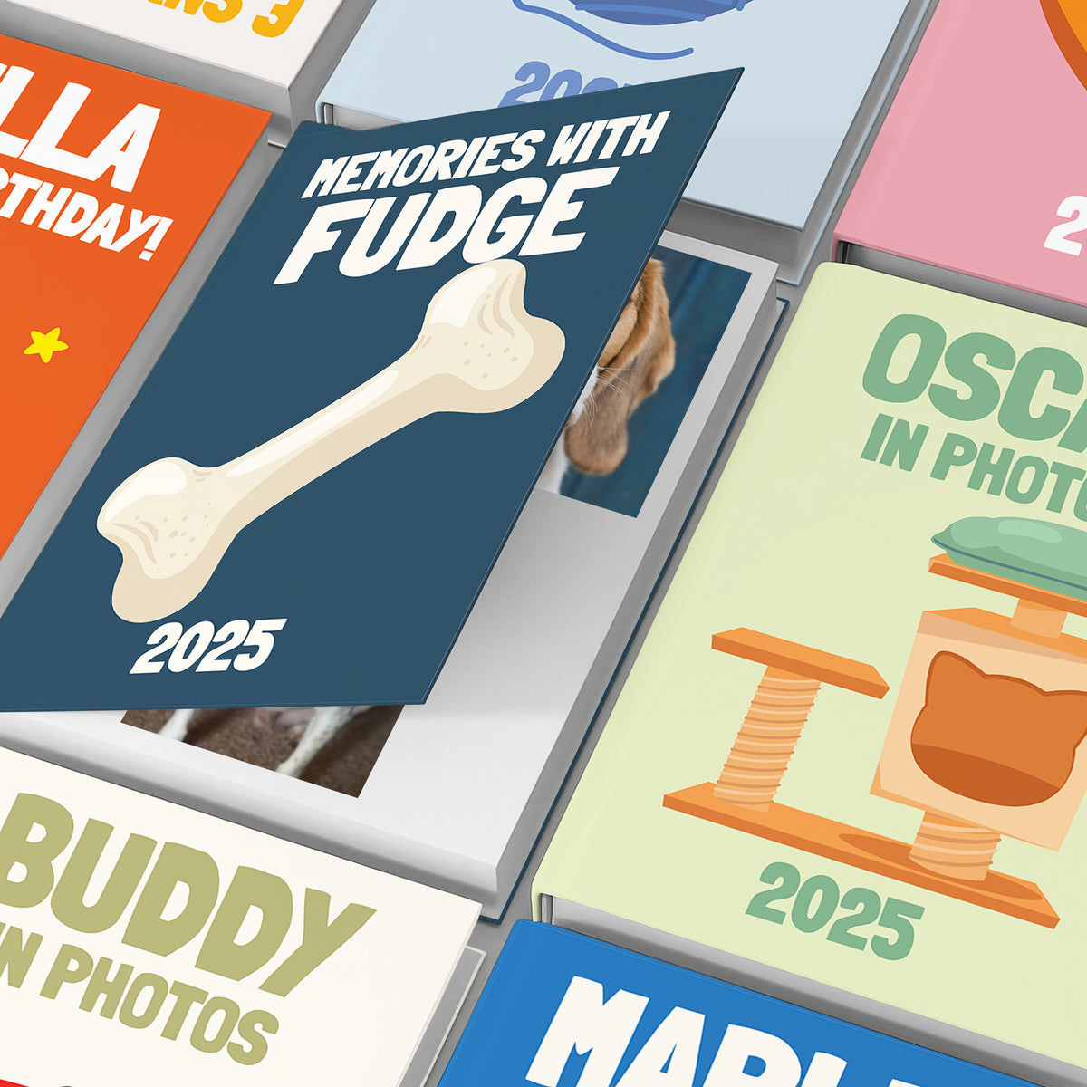 Close-up view of personalised pet photo book covers with custom names and illustrations.