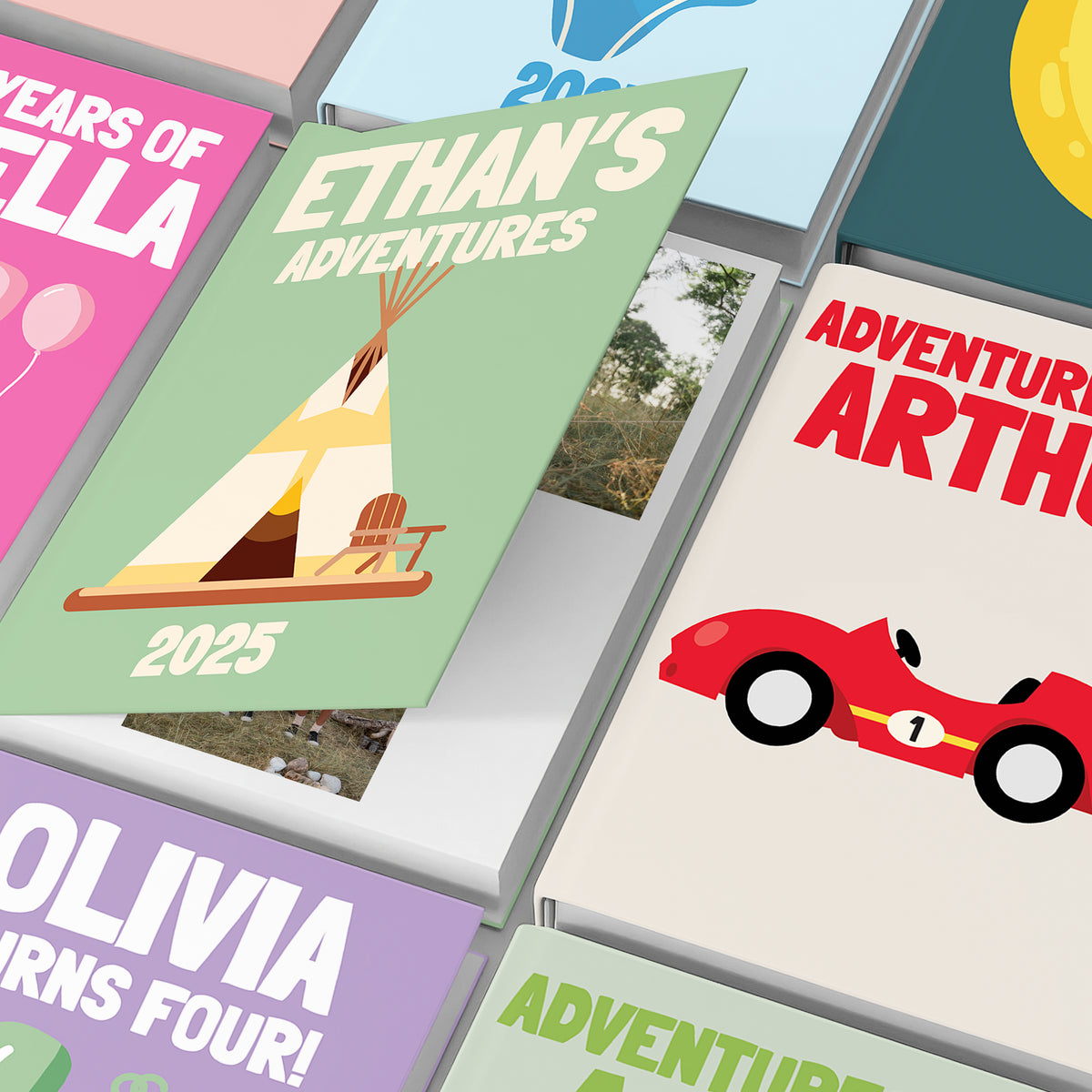 Close-up of personalised children’s photo book covers with bold names and illustrations.